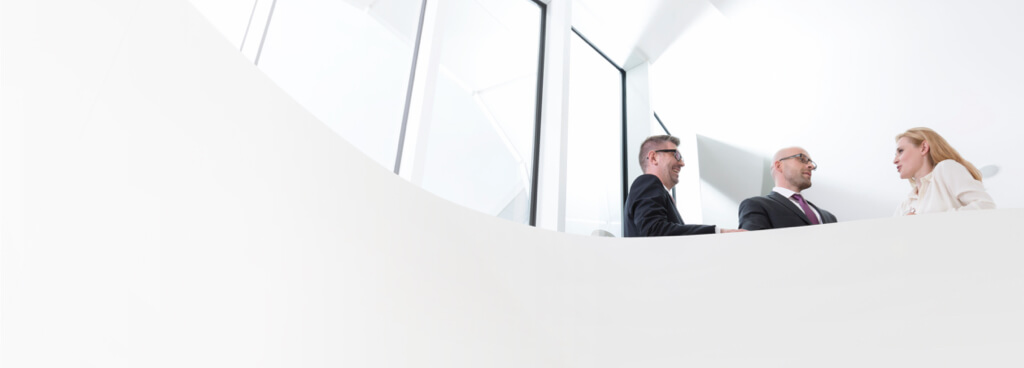 Zwei Männer und eine Frau unterhalten sich im Büro über die Business Partners Leistungen. Zwei Männer und eine Frau unterhalten sich im Büro über die Business Partners Leistungen.