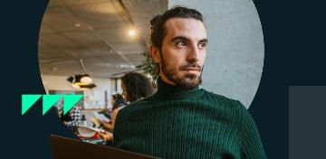 Ein Mann mit Bart steht in einem modern eingerichteten Raum.