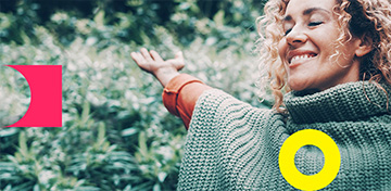 Eine Frau mit lockigem Haar hat die Augen geschlossen und lächelt.