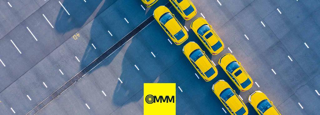 Auf einem Parkplatz sind von oben zwei Reihen parkender Autos zu sehen.