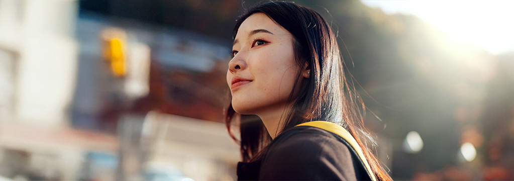 Junge Frau blickt zuversichtlich in die Ferne