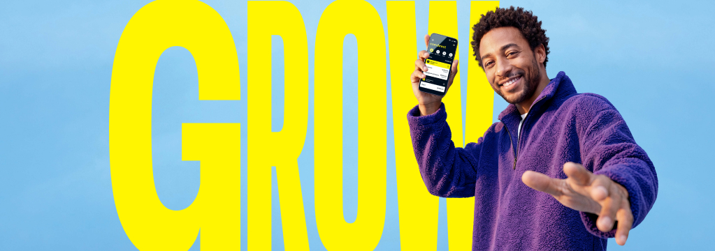 Ein Mann &ouml;ffnet die comdirect App auf seinem Smartphone. Im Hintergrund steht Text: Grow.