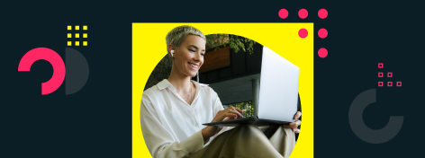 Eine Frau mit kabellosen Kopfhörern und weißer Bluse sitzt entspannt im Grünen und schaut auf ihren Laptop.