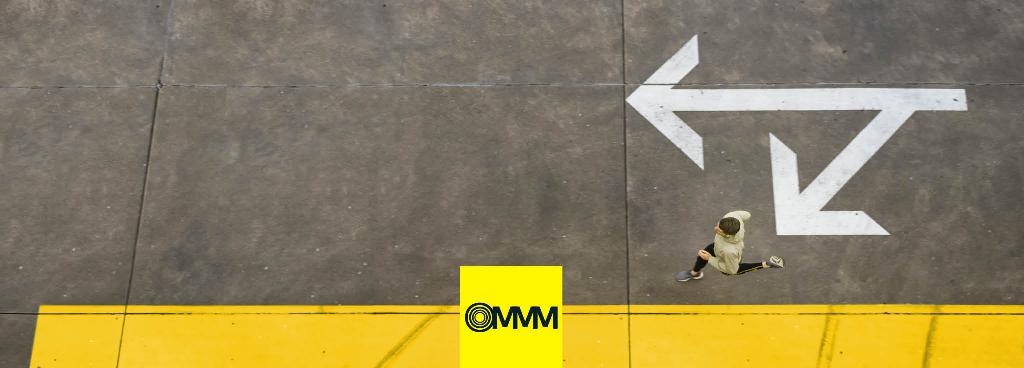 Ein Mann rennt über eine graue Fläche vorbei an zwei großen Pfeilen.