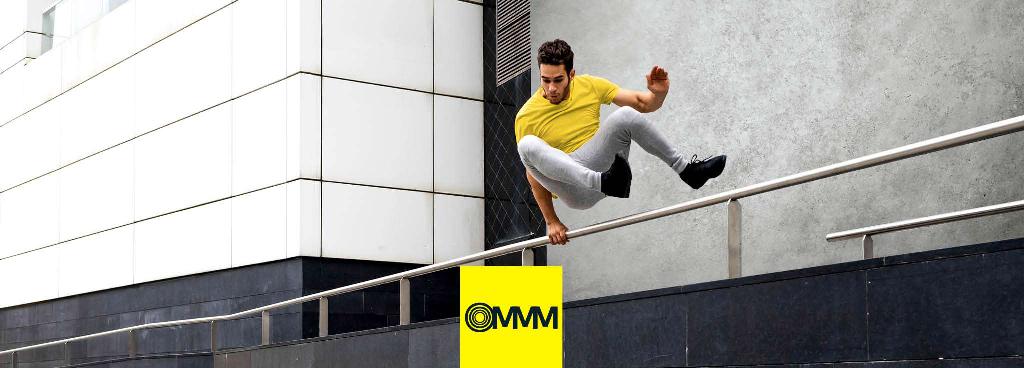 Ein junger Mann überspringt ein Hindernis in einem urbanen Setting.