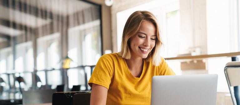 Eine junge blonde Frau lächelt in die Kamera.