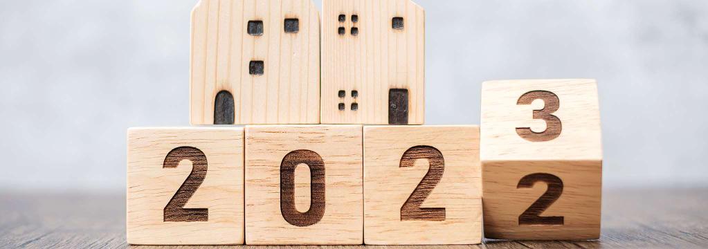 Nebeneinanderstehende Holzwürfel stellen den Übergang vom Jahr 2022 hin zum Jahr 2023 dar.