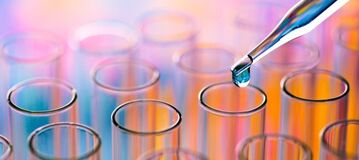 Biotech-Aktien &ndash; Nahaufnahme einer Pipette, von der eine Fl&uuml;ssigkeit in ein Reagenzglas tropft