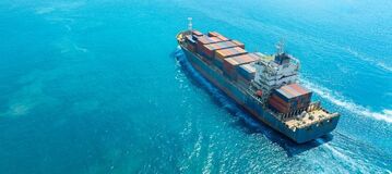 Ein Containerschiff f&auml;hrt &uuml;ber den Ozean.