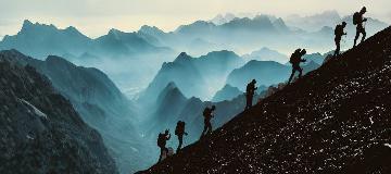 Eine Gruppe von Bergsteigern steigt einen steilen Berghang hinauf.