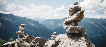 Verschiedene gro&szlig;e und kleine Steine sind in einer Berglandschaft aufeinandergestapelt.