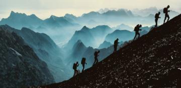 Eine Gruppe von Bergsteigern steigt einen steilen Berghang hinauf.