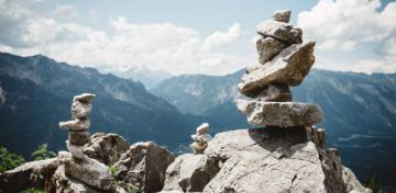 Verschiedene gro&szlig;e und kleine Steine sind in einer Berglandschaft aufeinandergestapelt.