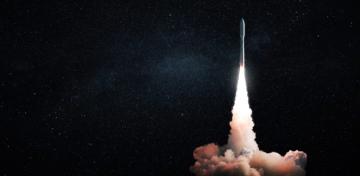 Eine Rakete startet mit einer wei&szlig;en Rauchwolke in das schwarze Weltall.