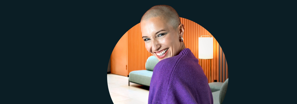 Eine Frau in einem Strickpullover steht in einem modernen Wohnzimmer.