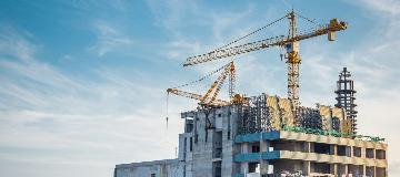 Auf einem Hochhaus-Rohbau stehen mehrere Braukr&auml;ne.