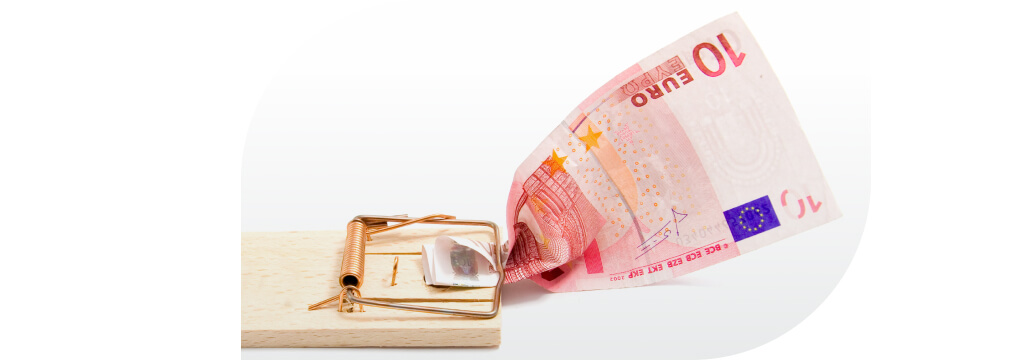 Ein 10-Euro-Schein ist in einer Mausefalle eingeklemmt.